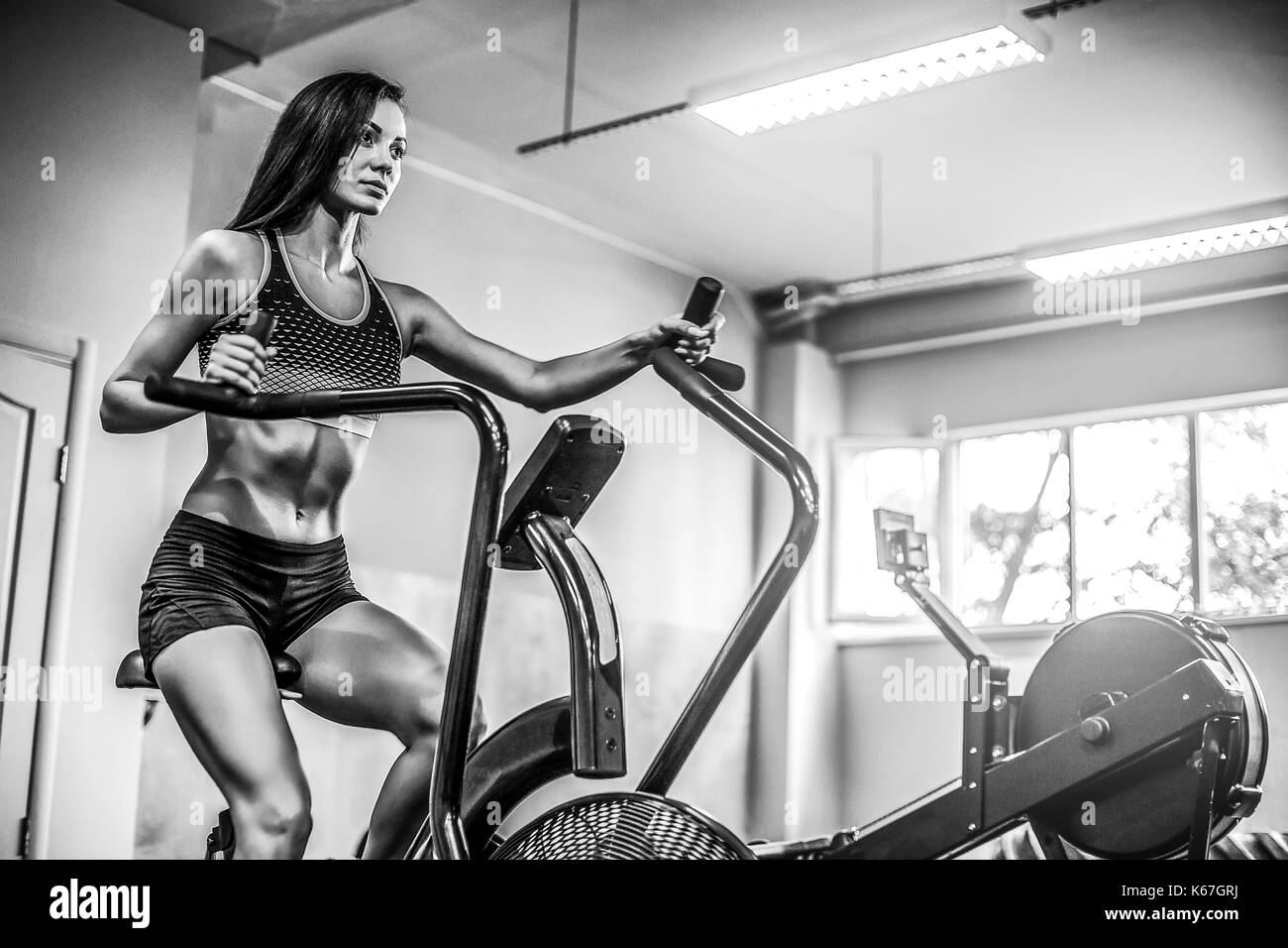Femme de remise en forme de l'air à l'aide de vélo cardio Gym crossfit à. Banque D'Images