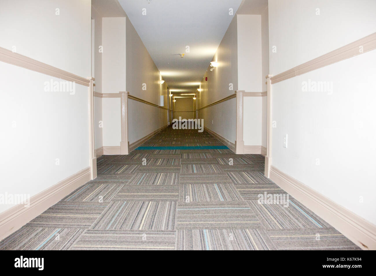 Un long couloir beige vide dans un immeuble Banque D'Images