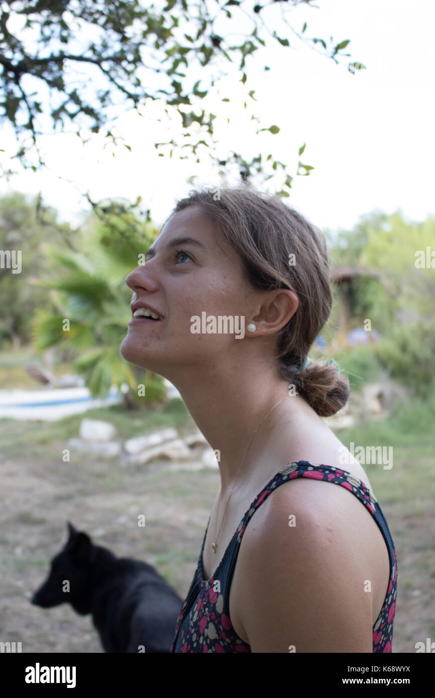 Teenage girl avec cheveux tirés en arrière en un chignon à l'extérieur en été. Vu de côté. Banque D'Images