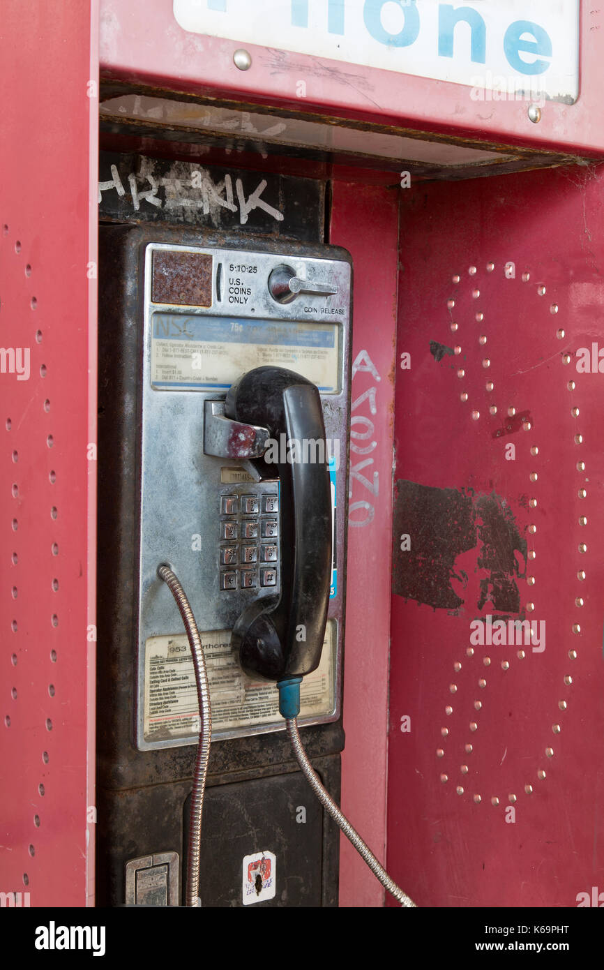Téléphone public à pièces abandonnées avec coin presse logement. Banque D'Images