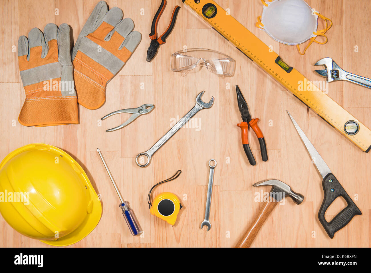 Casque de sécurité et des outils de construction de l'offre sur un bureau en bois Banque D'Images