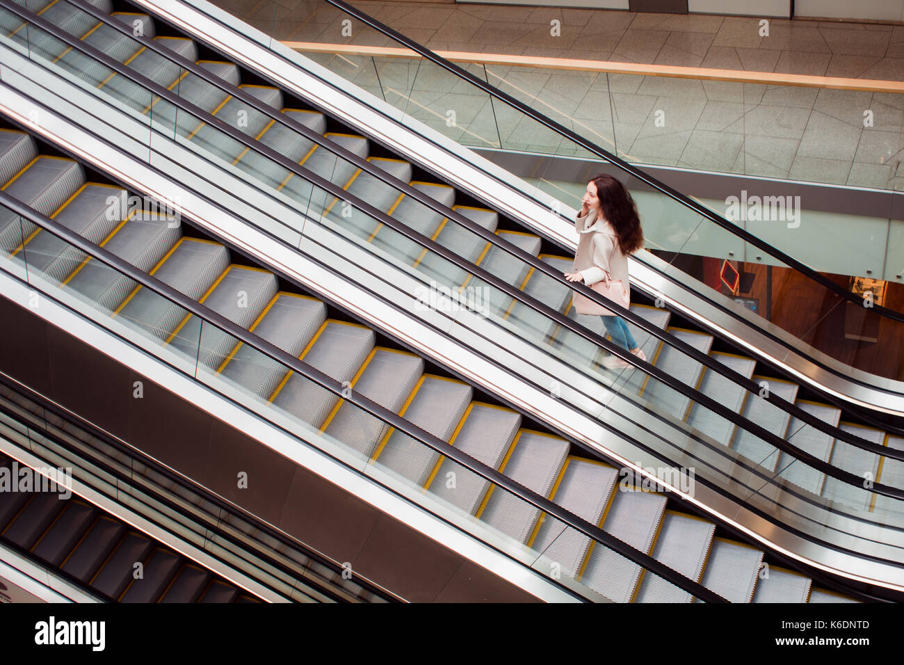 Jeune femme au centre commercial en descendant l'escalier, vue à partir du haut Banque D'Images