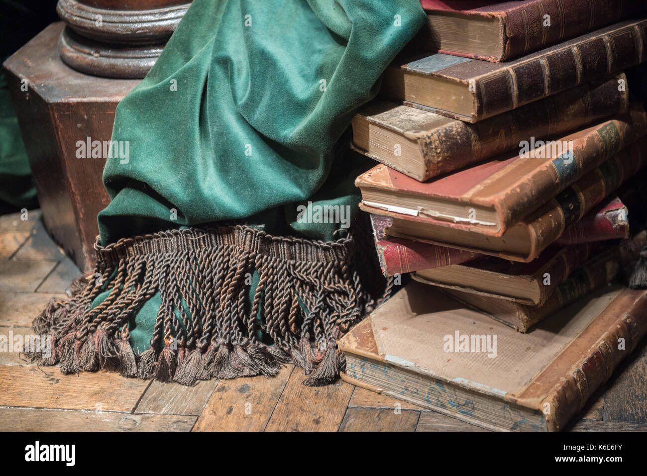 Pile de vieux livres avec chaise en bois et rideau vert Banque D'Images