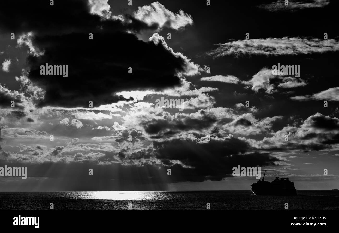 Photographie en noir et blanc d'bateau de croisière naviguant dans le coucher du soleil - prises de Bridgetown, Barbade Banque D'Images