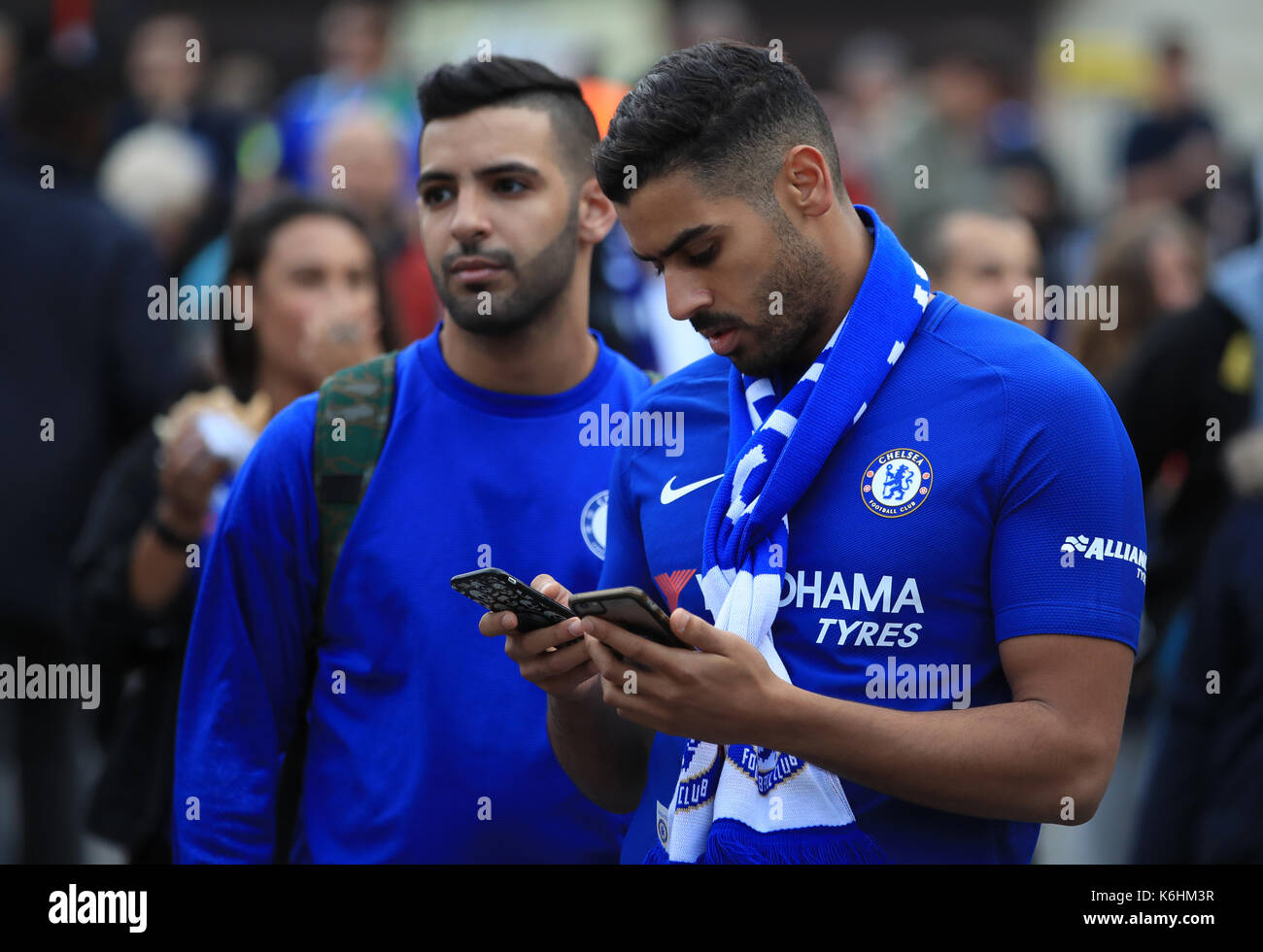 Un ventilateur chelsea vérifie son téléphone avant de le la ligue des champions, groupe c match à Stamford Bridge, Londres. Banque D'Images