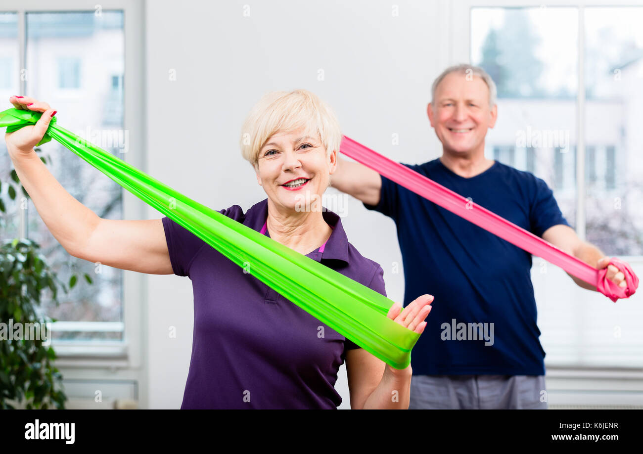 Couple de personnes âgées dans la haute classe de gymnastique faire entraînement avec caout Banque D'Images