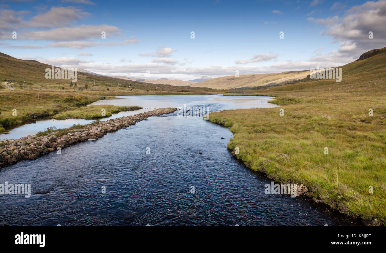 Les eaux bleues d'un' ghairbhe river sèche du loch clair lac sur le coulin estate dans la vallée de Glen Torridon, sous les montagnes de l'ouest highlan Banque D'Images
