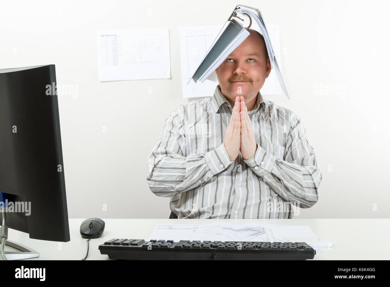 Dossier avec l'architecte sur la tête en priant à 24 Banque D'Images