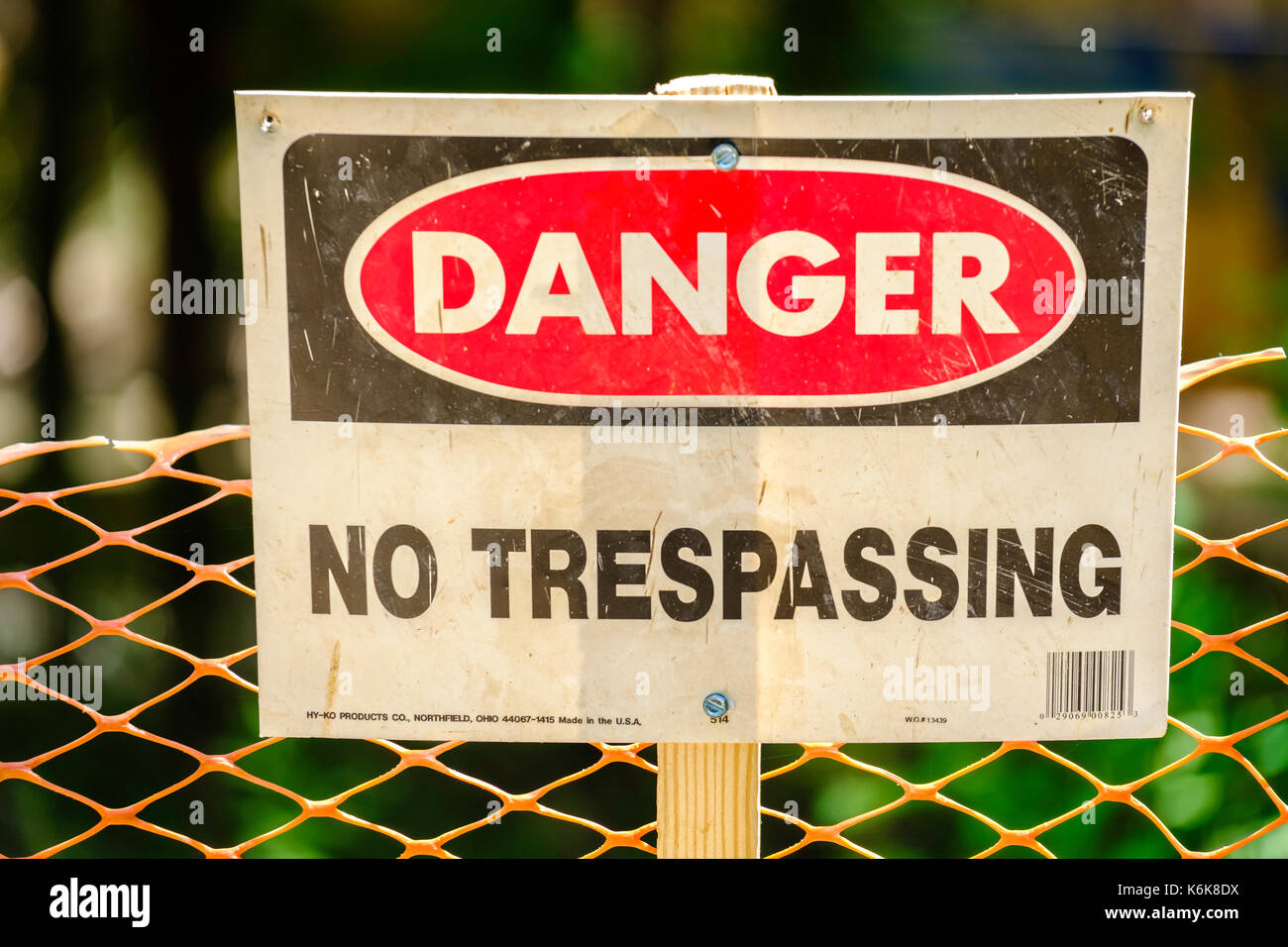 Un signe en face d'une clôture en plastique, d'avertissement de danger, aucune intrusion. USA. Banque D'Images