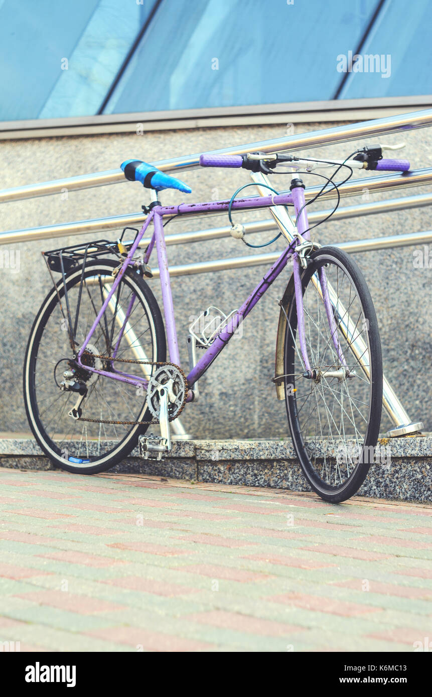 Vieux vélo de route de couleur rose avec un ridicule rembobinée siège ruban électrique bleu. le vélo ou le navettage dans l'environnement urbain de la ville, transport écologique Banque D'Images