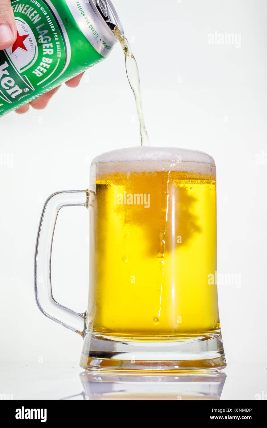 Verser une rafraîchissante bière Heineken dans un verre givré. Banque D'Images