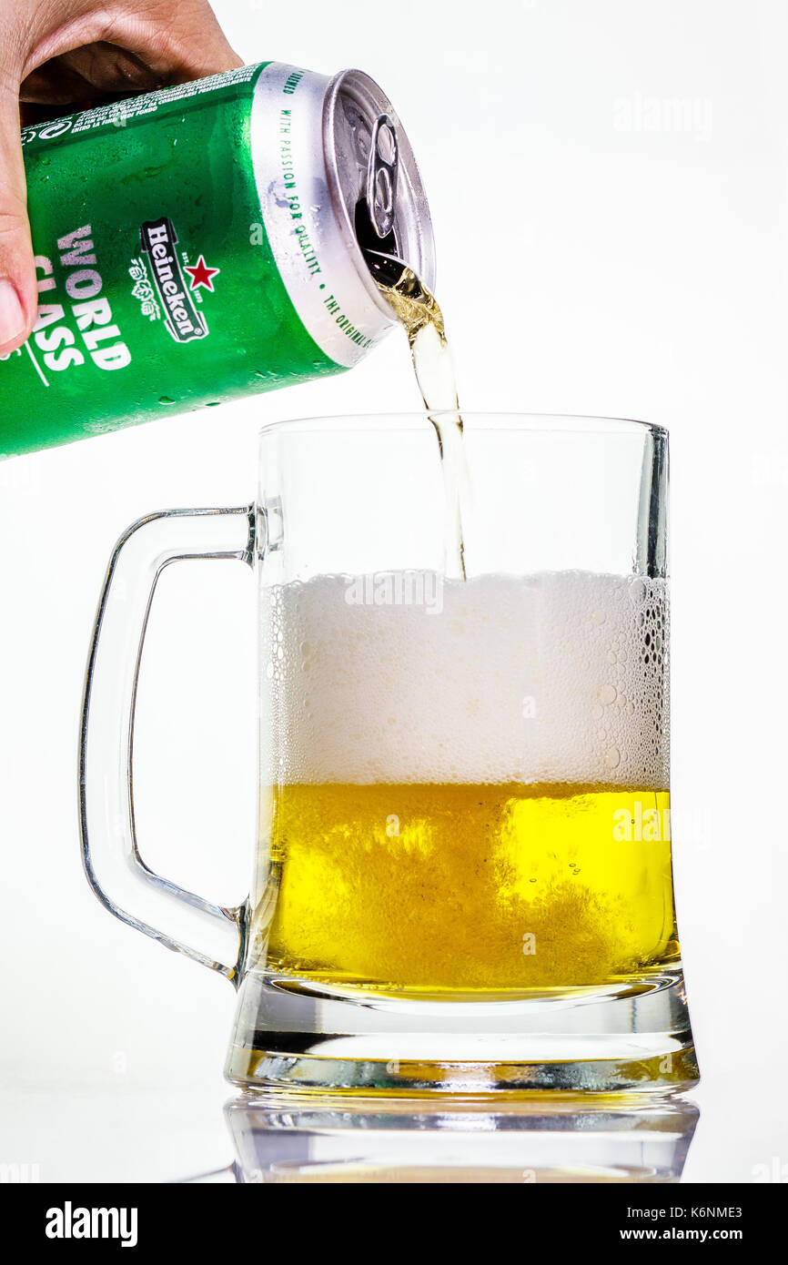 Un froid peut de Heineken versé dans une tasse en verre sur un fond blanc Banque D'Images