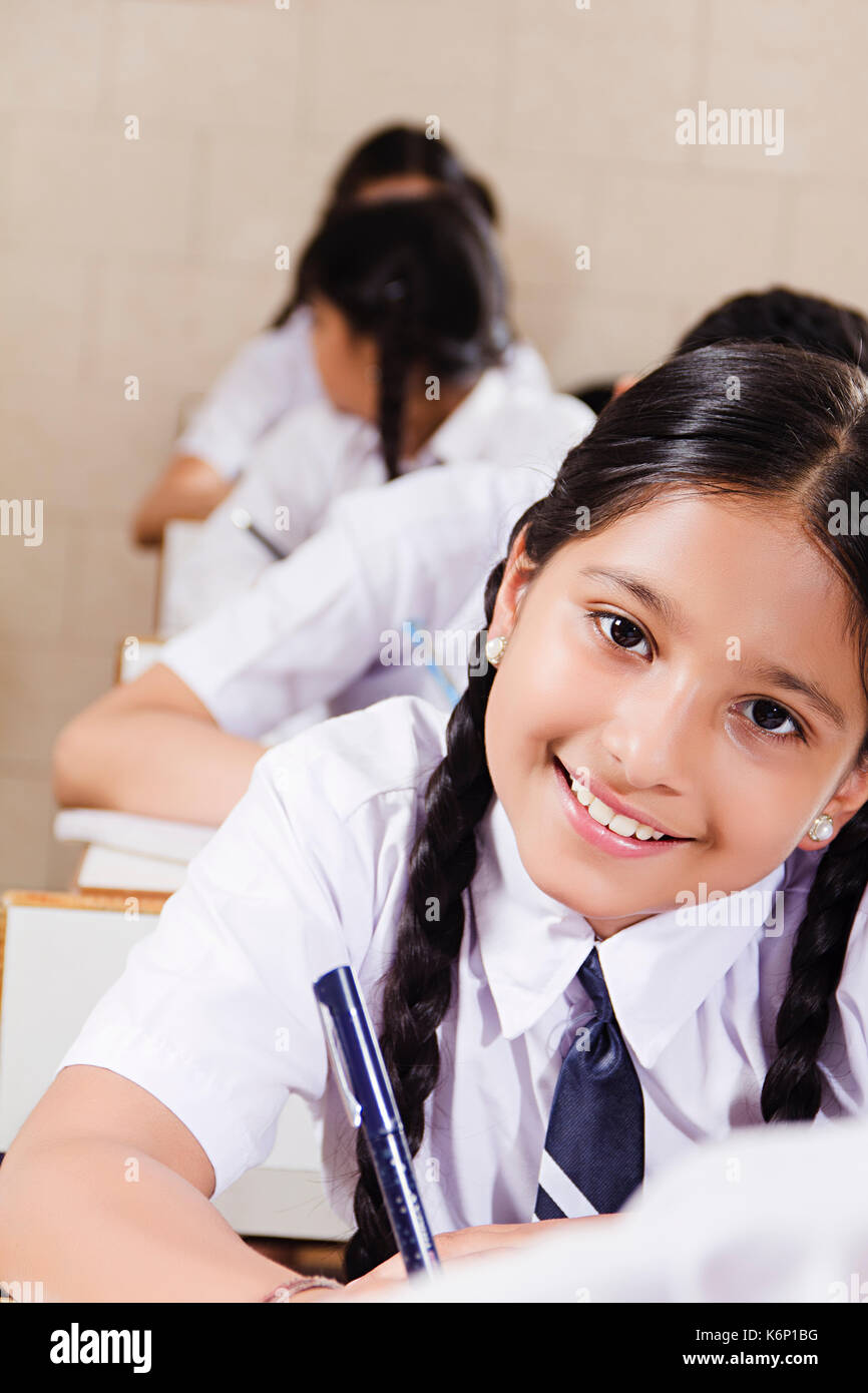 Smiling indian school kid girl 1 manuel de l'élève l'étude de l'éducation en salle de classe Banque D'Images