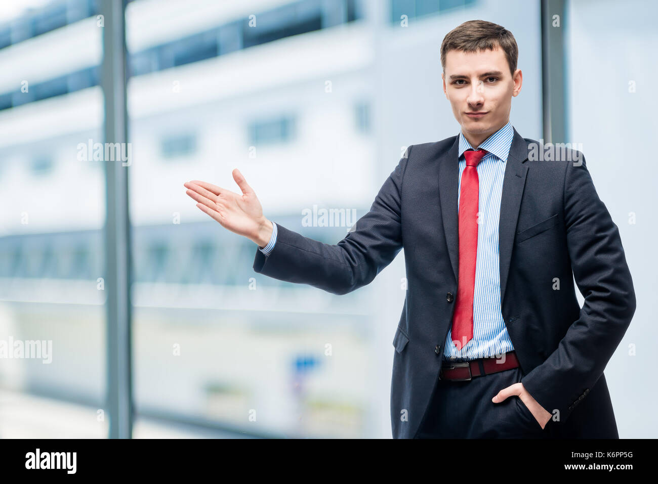 Jeune homme d'affaires montrant sa main sur quelque chose in office Banque D'Images