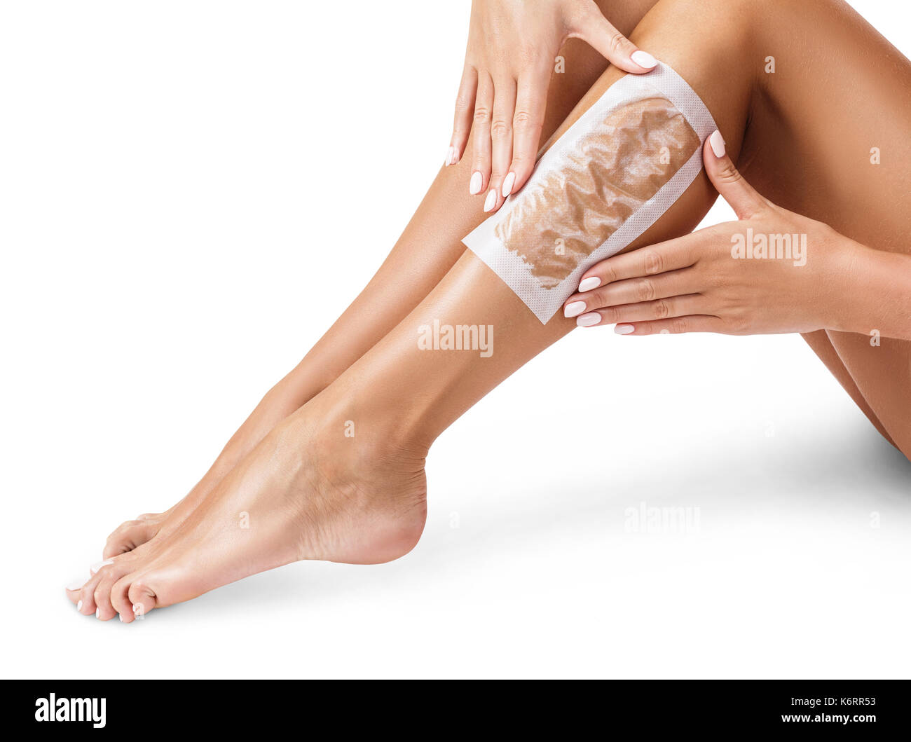 Les jambes des femmes avec des bandes d'épilation à la cire épilation. procédure par bandes. Banque D'Images