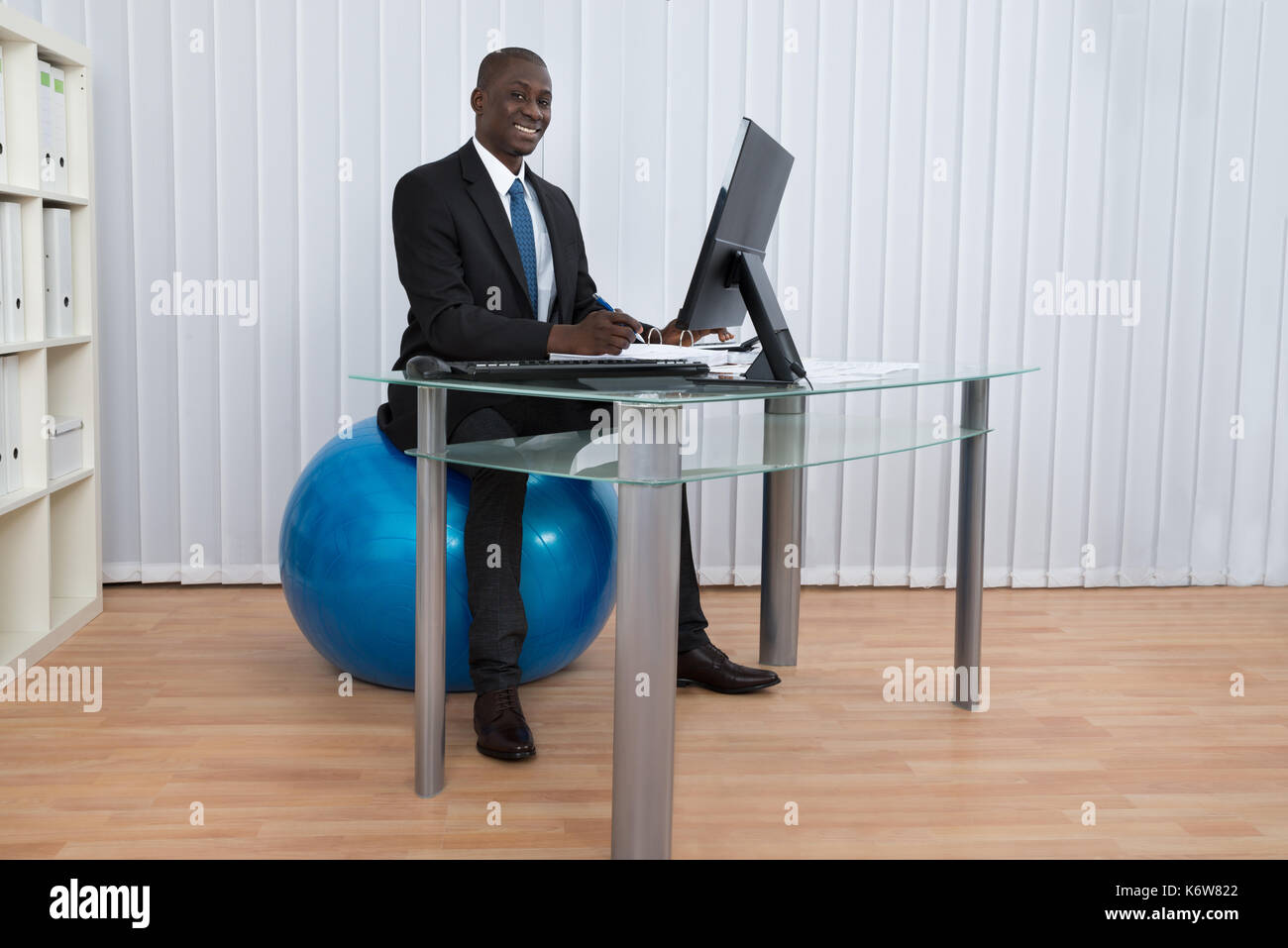 Portrait of happy young woman sitting on travail pilates ball Banque D'Images