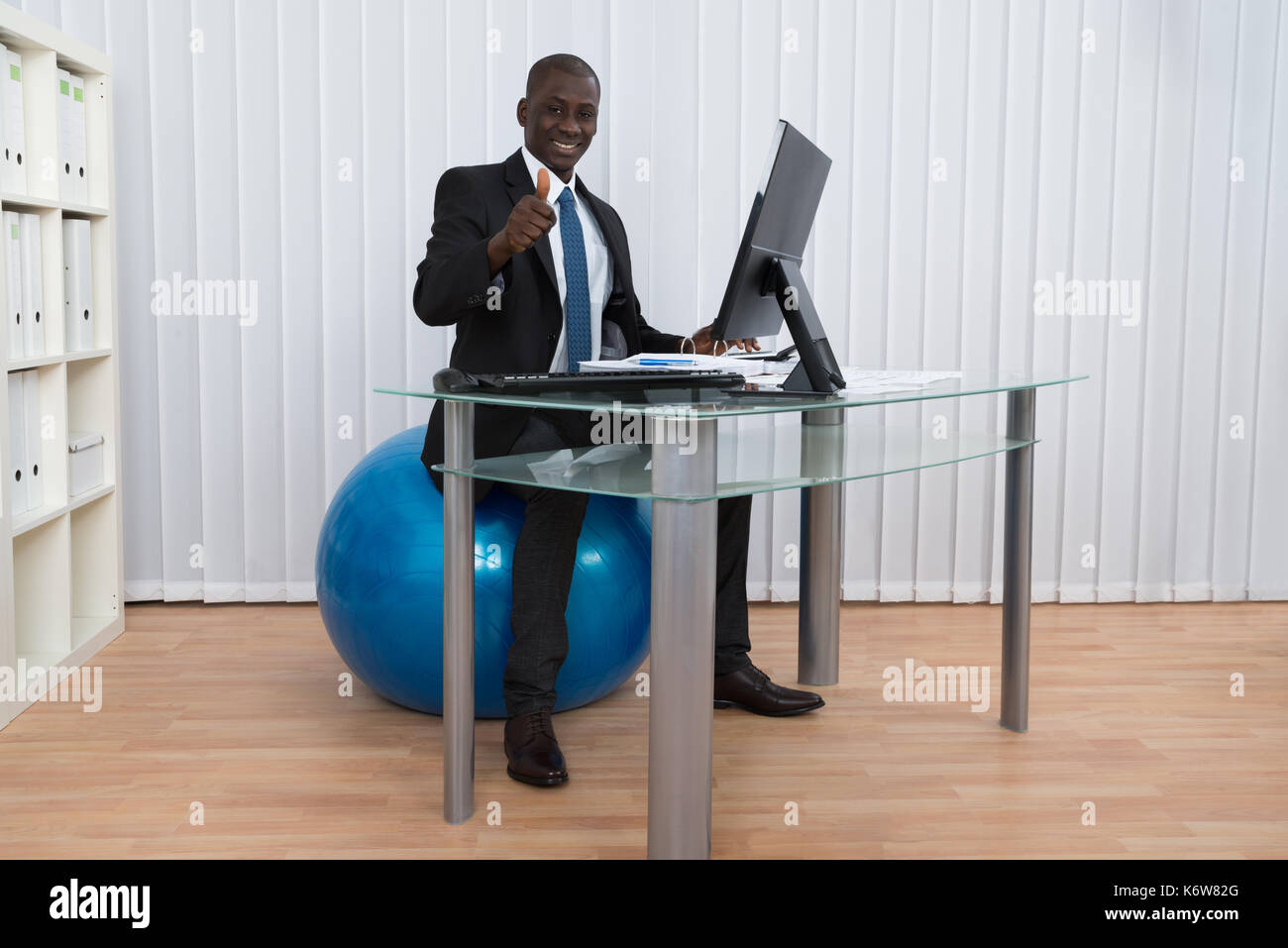 Portrait of happy young woman sitting on travail pilates ball Banque D'Images