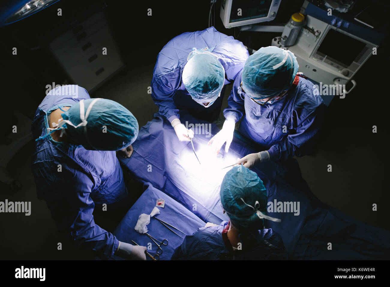 Vue de dessus d'équipe de chirurgiens d'effectuer la chirurgie en salle d'opération. Groupe de médecins à l'hôpital d'opération. Banque D'Images