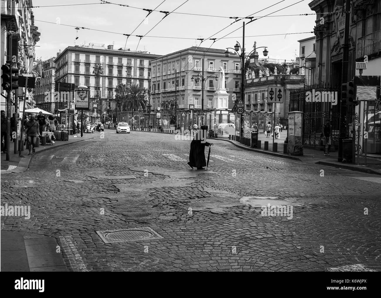 Vieille dame en noir Crossing Road à Naples Image en noir et blanc Banque D'Images