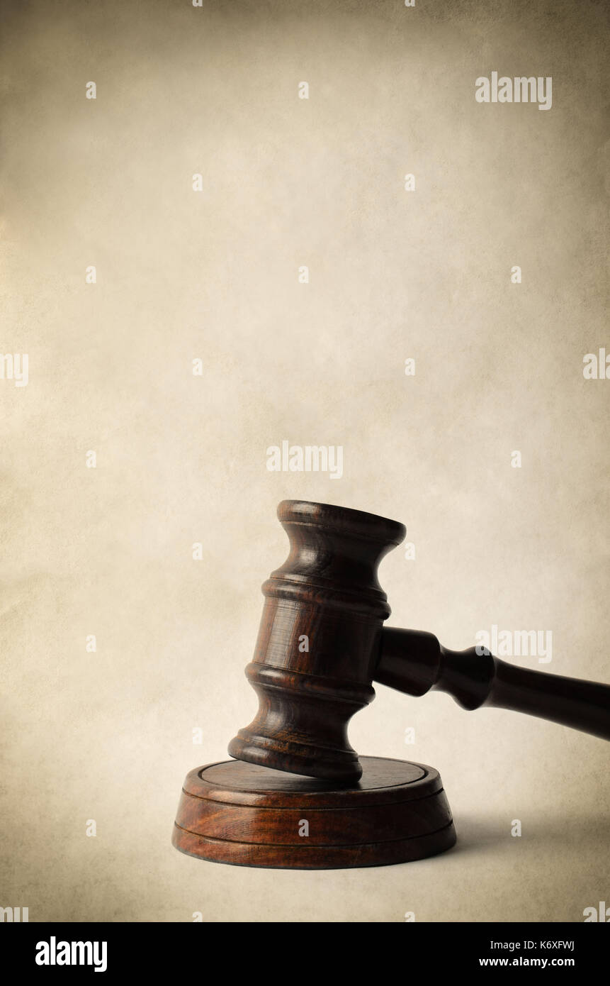 Un marteau en bois foncé avec bloc circulaire sur fond parchemin de fournir copie espace ci-dessus. vintage ou style rétro. Banque D'Images