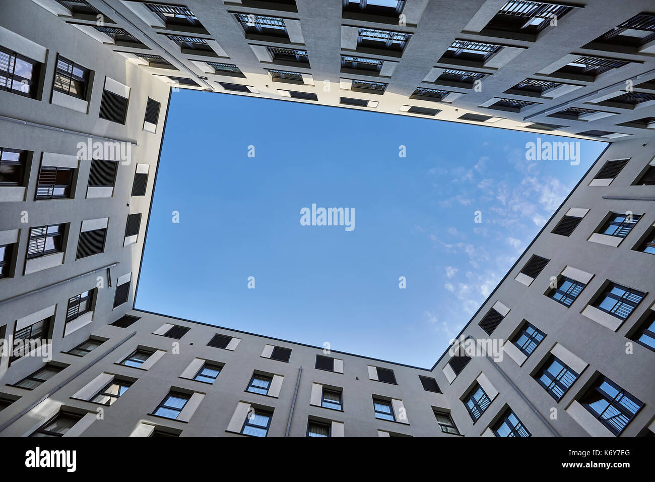 Géométrique moderne gray maison sur le ciel bleu avec des nuages de fond. soleil brille sur son sommet. vue depuis le bas. à l'horizontale. Banque D'Images