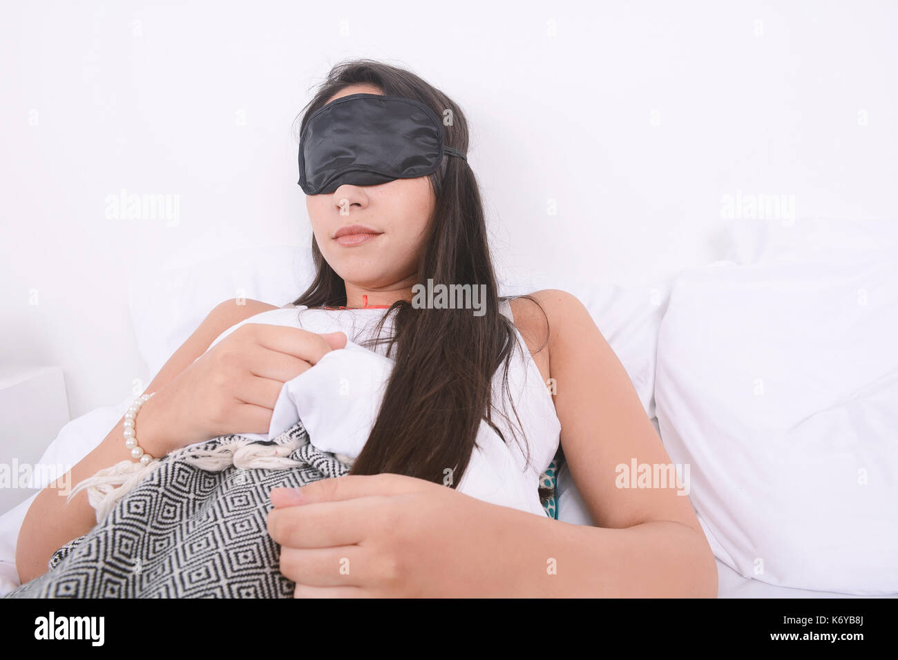 Close-up of beautiful young woman sleeping in bed avec un masque pour les yeux. à l'intérieur. Banque D'Images