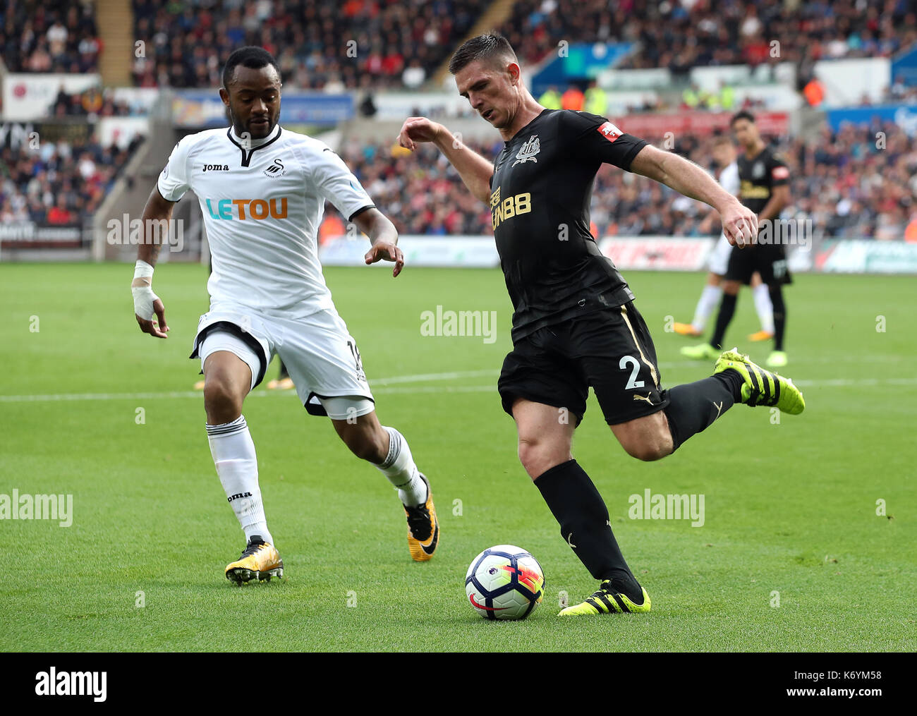 Swansea City's Jordan Ayew (à gauche) et du Newcastle United ciaran clark (à droite) bataille pour la balle Banque D'Images