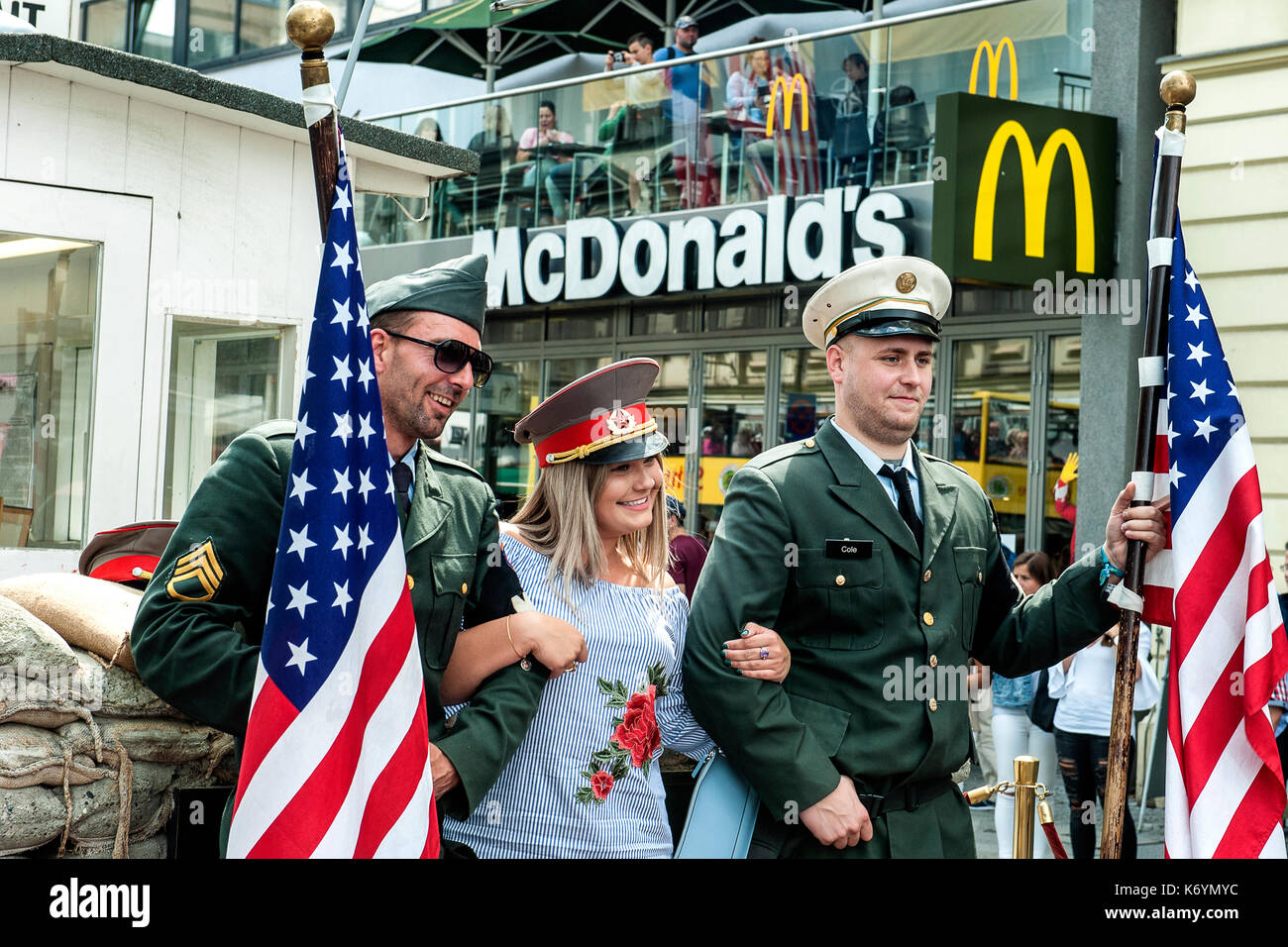 Une américaine est photographié entre deux cosplayeuse habillée par les soldats américains à Check Point Charlie sur un arrière-plan de restauration rapide mcdonald, Berlin Banque D'Images