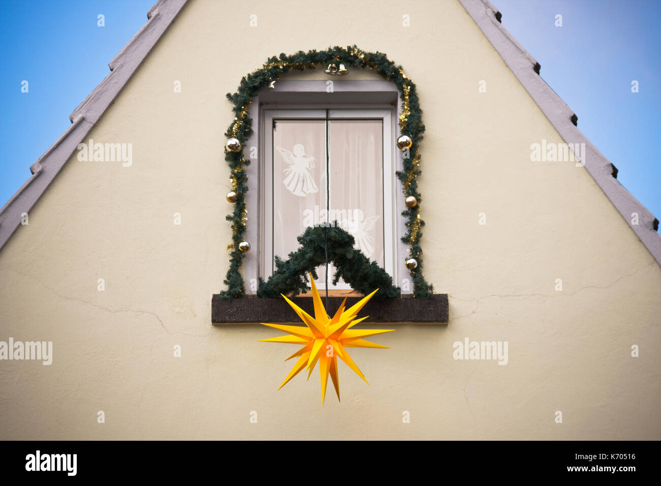 Une grande étoile de Noël jaune et d'autres décorations de Noël sur une fenêtre. Banque D'Images