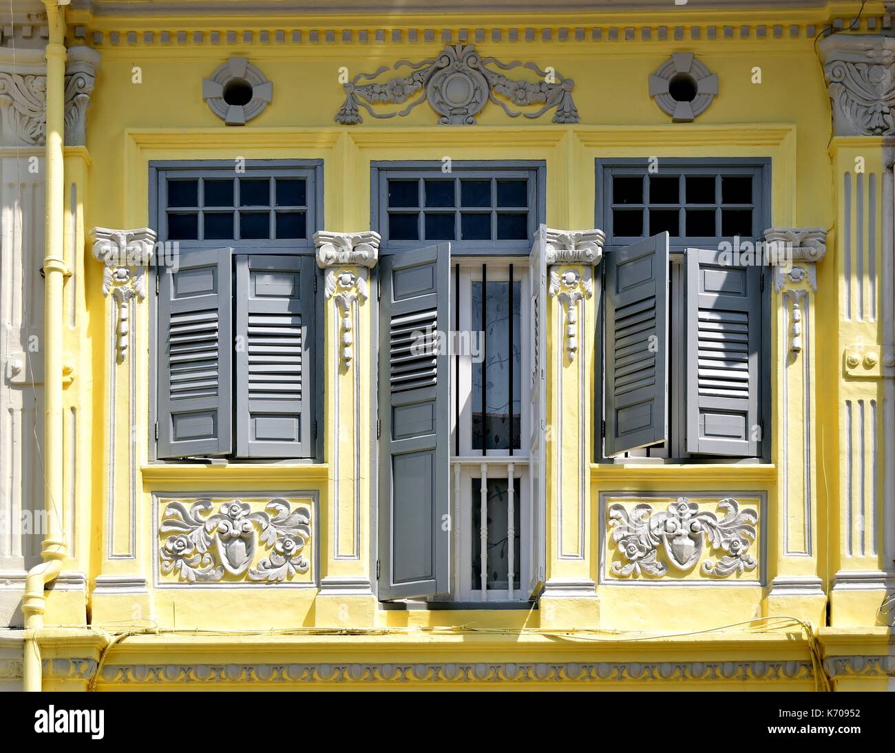 Extérieur de maison boutique traditionnelle avec façade en bois jaune, gris majorquines et des sculptures de l'everton park historique de Singapour Banque D'Images