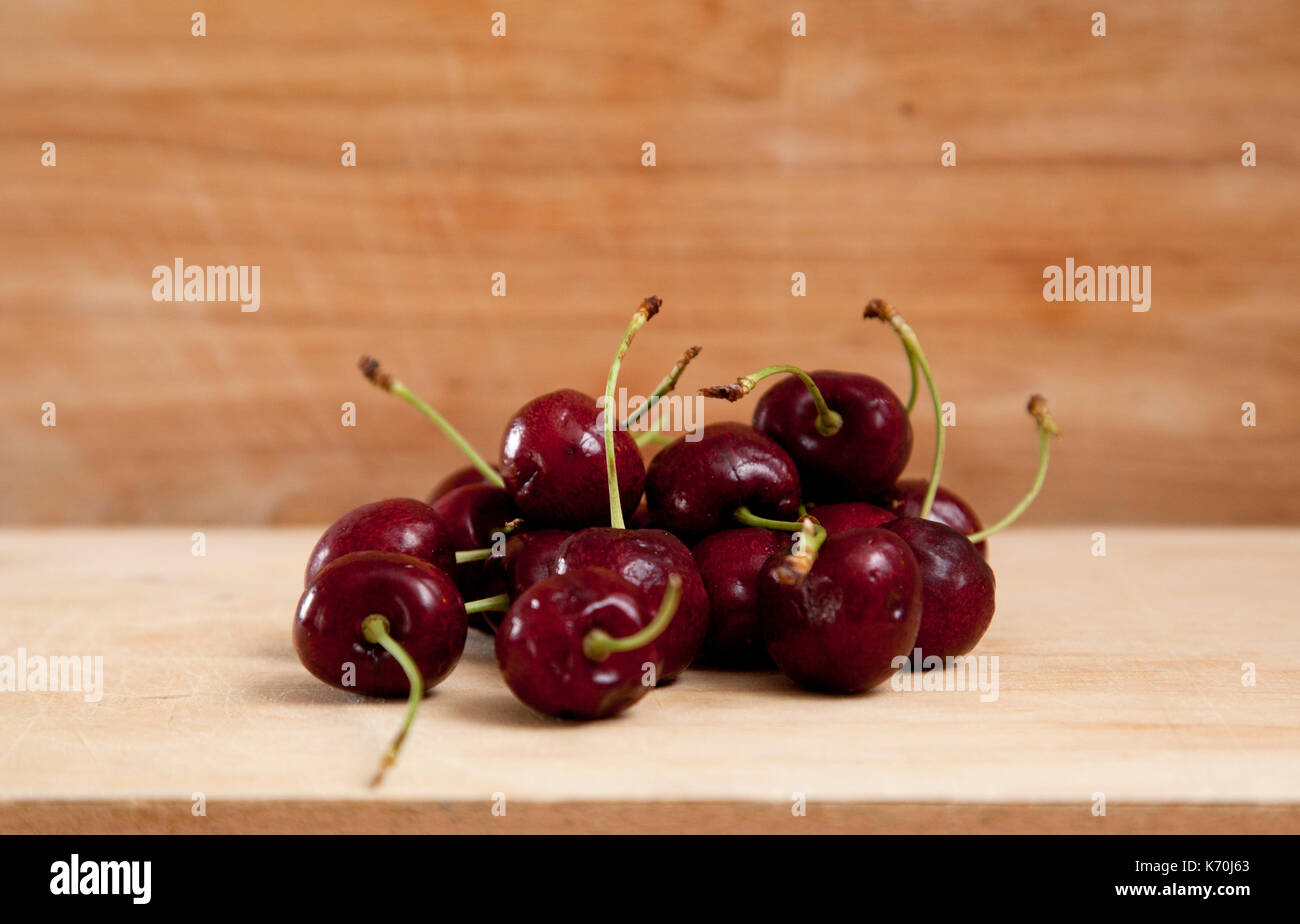 Belle couleur rouge cerise noire ou contre une planche en bois, prêt à manger Banque D'Images