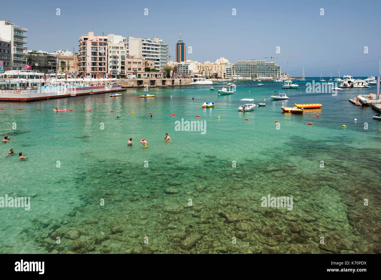 La natation de personnes dans la baie de Balluta à Malte. Banque D'Images