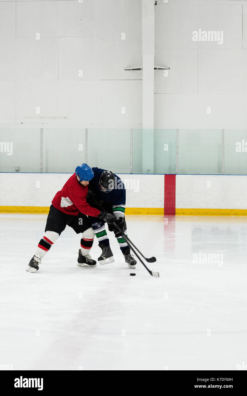 Toute la longueur de joueurs masculins à jouer au hockey sur glace rink Banque D'Images