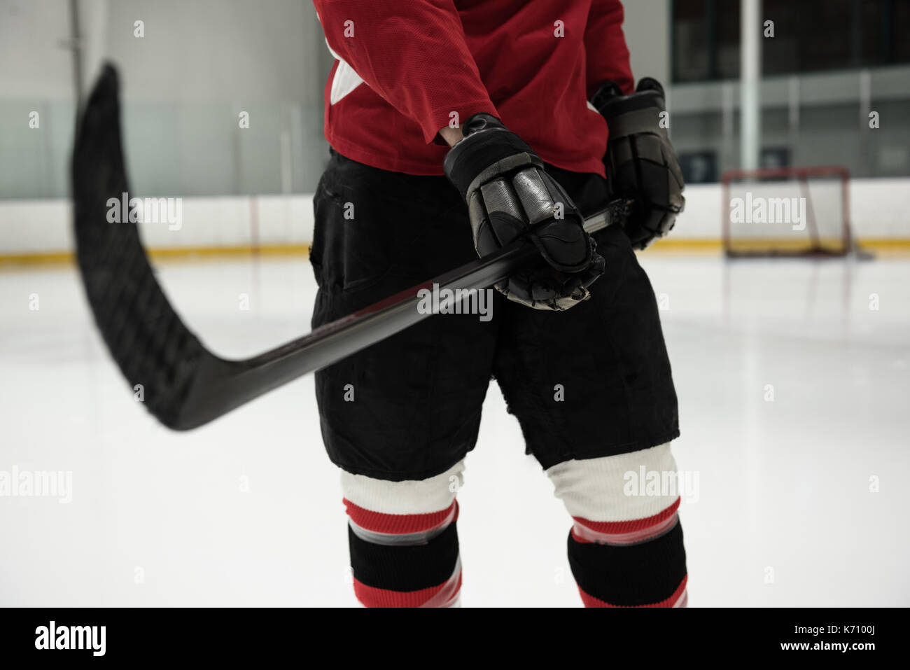 Section intermédiaire de hockey player holding stick à patinoire Banque D'Images