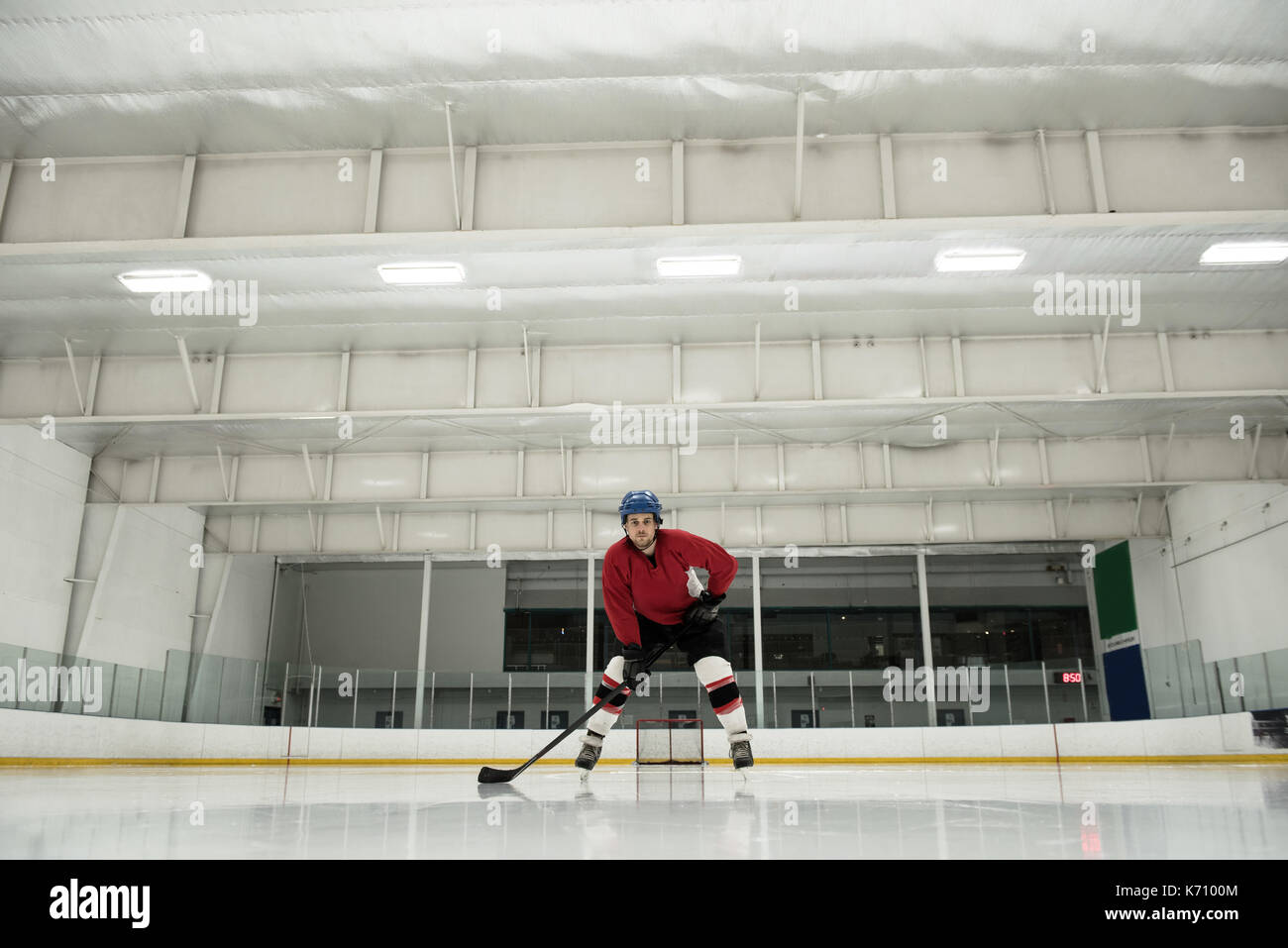 Toute la longueur de l'homme joueur de jouer au hockey sur glace rink Banque D'Images