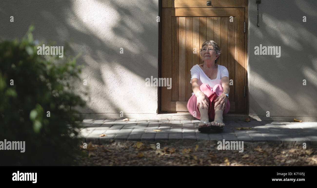 Happy woman sitting devant la porte et Banque D'Images