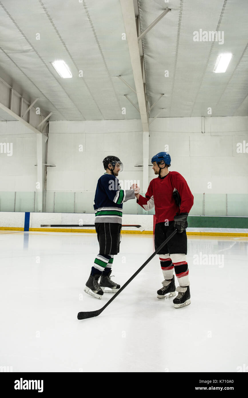 Toute la longueur de joueurs de hockey sur glace masculin shaking hands at rink Banque D'Images