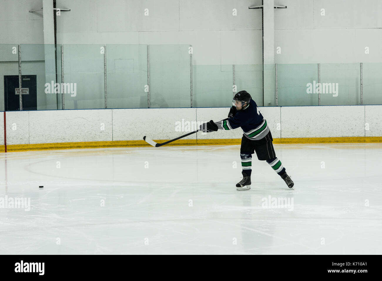 Toute la longueur de l'homme joueur de jouer au hockey sur glace rink Banque D'Images