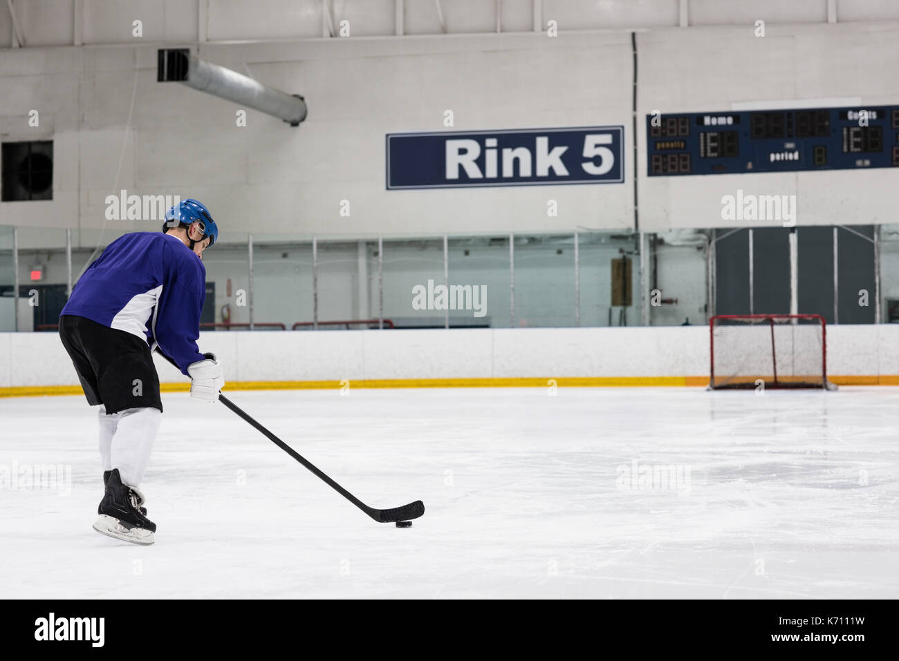 Toute la longueur du joueur de hockey sur glace masculin pratiquant à rink Banque D'Images