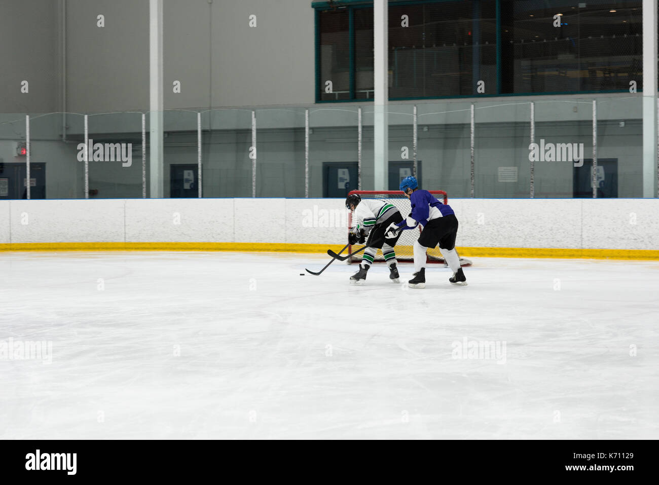Les joueurs masculins à jouer au hockey sur glace rink Banque D'Images
