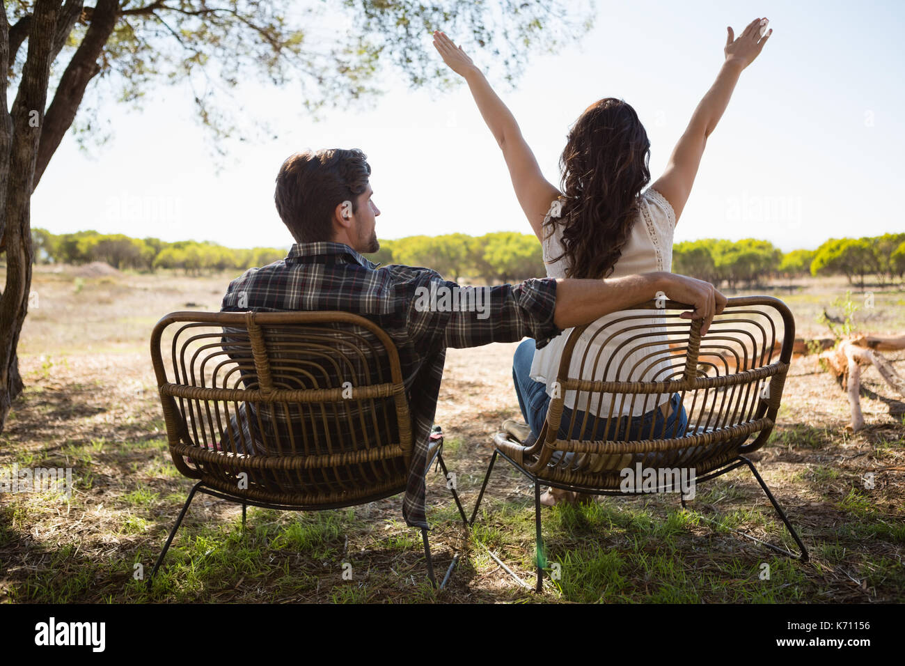 Vue arrière de la femme par l'homme a assis sur une chaise sur le terrain Banque D'Images
