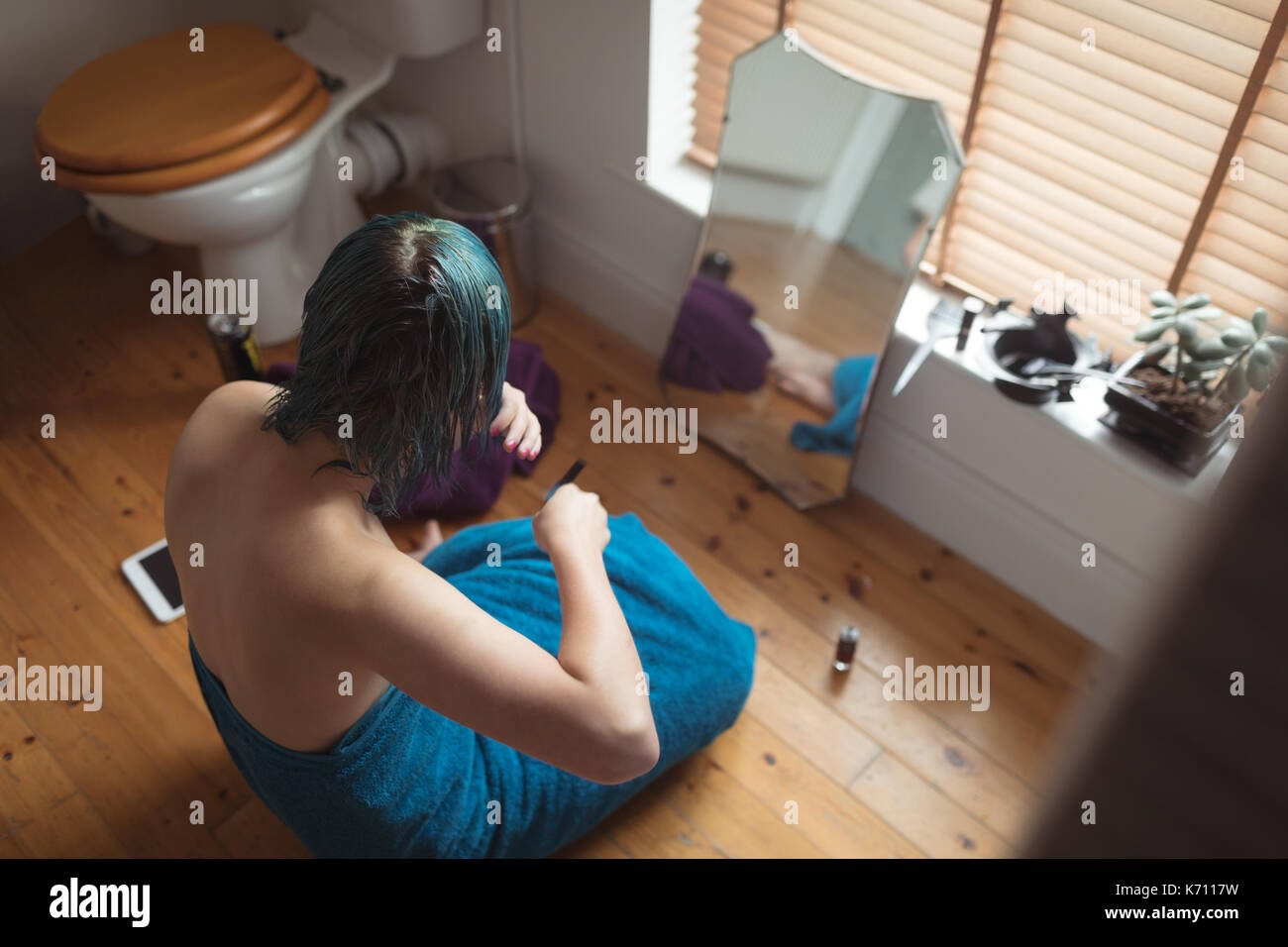 Portrait de jeune femme avec les cheveux teints par fenêtre dans salle de bains Banque D'Images