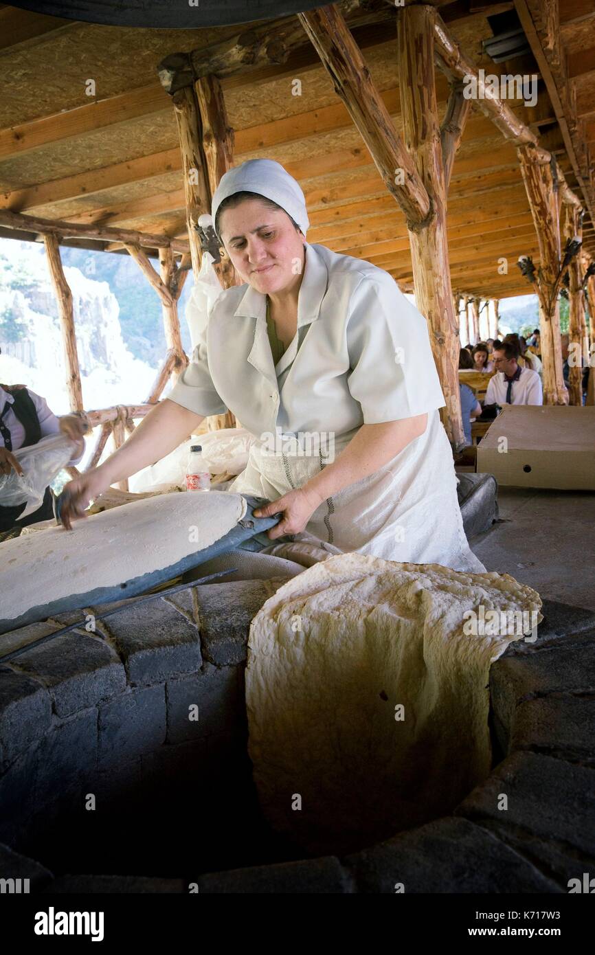 L'Arménie, Erevan, Garni Temple païen, dame arménienne, la préparation du pain sans levain, Lavash sur un four en pierre et en bois à Garnitoun au restaurant Banque D'Images