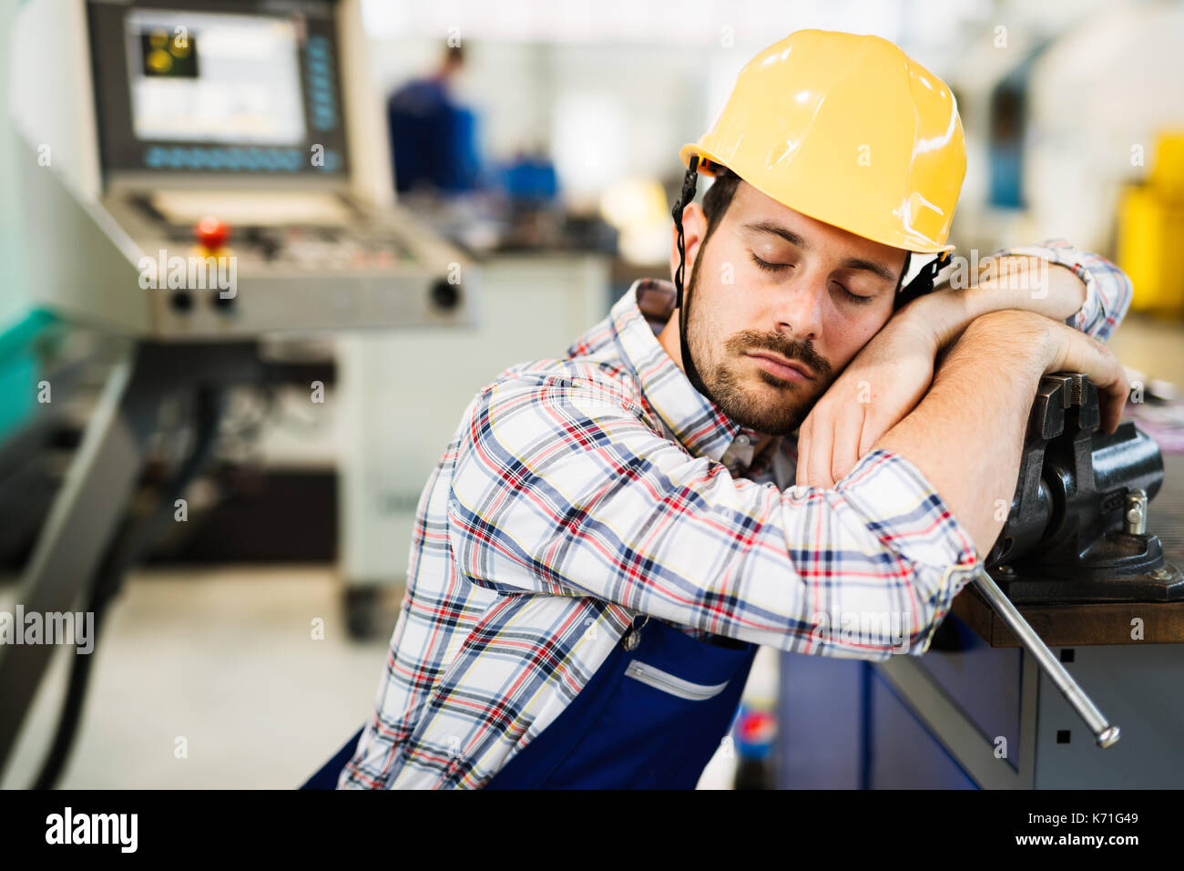 Travailleur fatigué s'endormir pendant les heures de travail en usine Banque D'Images