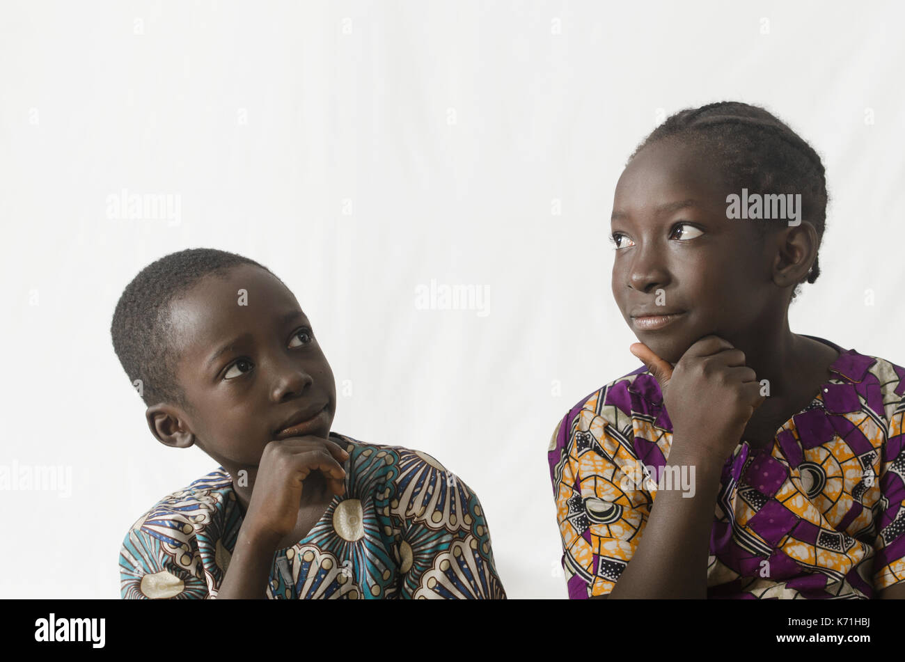 Deux enfants africains de penser avec les mains sur le menton, isolated on white Banque D'Images