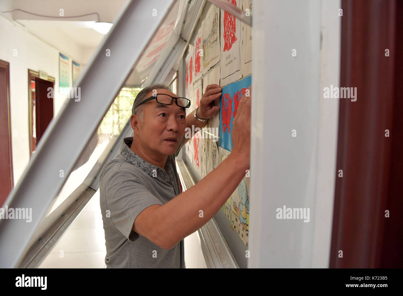 (170914) -- nanchang, sept. 14, 2017 (Xinhua) -- il place les élèves xingwu' tricot dans un showwindow à une école spéciale à Nanchang, province de Jiangxi en Chine de l'Est, sept. 13, 2017. Les 74 ans, enseignant, il xingwu a travaillé dans l'école spéciale depuis 23 ans. Il a perdu l'audition à l'âge de huit ans en raison de l'utilisation inappropriée de médicaments. En 1994, lui et son ami a fondé l'école après sa retraite. plus de 300 à l'audition et des malentendants francophones les étudiants ont obtenu un diplôme de l'école. (Xinhua/peng zhaozhi) (zkr)(zt) Banque D'Images