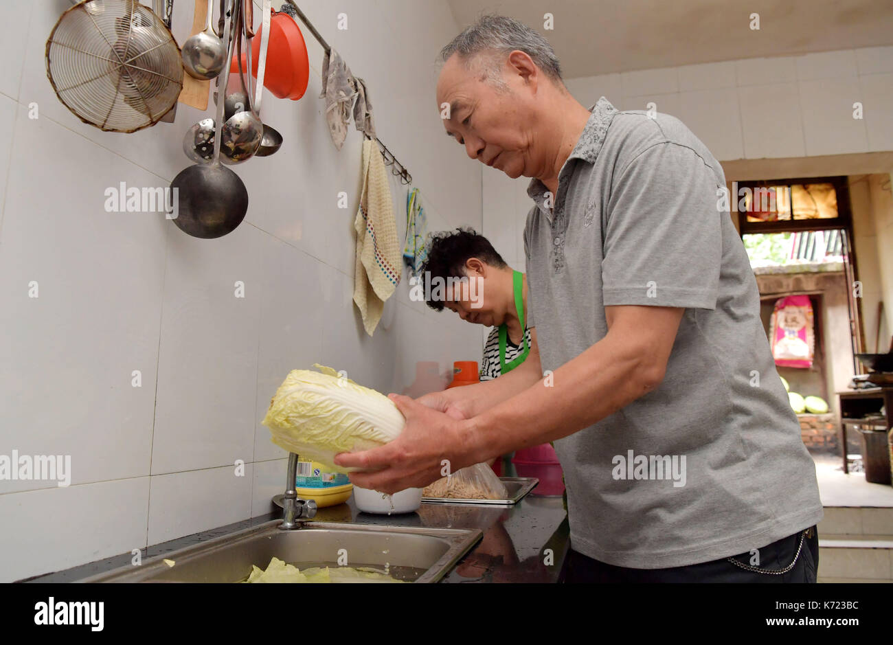 (170914) -- nanchang, sept. 14, 2017 (Xinhua) -- il xingwu et sa femme cuisiner le déjeuner pour les élèves à une école spéciale à Nanchang, province de Jiangxi en Chine de l'Est, sept. 13, 2017. Les 74 ans, enseignant, il xingwu a travaillé dans l'école spéciale depuis 23 ans. Il a perdu l'audition à l'âge de huit ans en raison de l'utilisation inappropriée de médicaments. En 1994, lui et son ami a fondé l'école après sa retraite. plus de 300 à l'audition et des malentendants francophones les étudiants ont obtenu un diplôme de l'école. (Xinhua/peng zhaozhi) (zkr)(zt) Banque D'Images