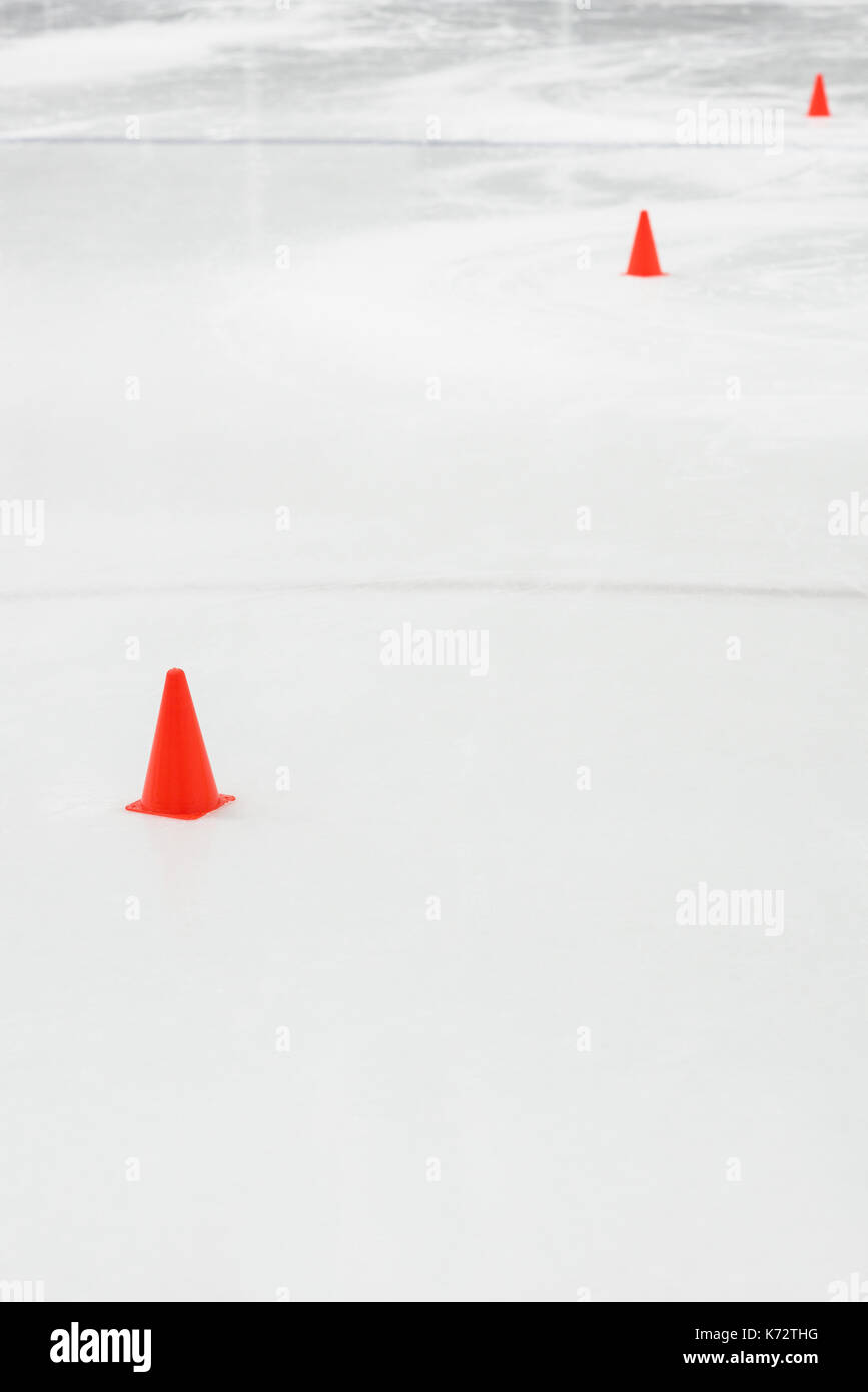 Cônes d'entraînement sportif au hockey sur glace rink vide Banque D'Images