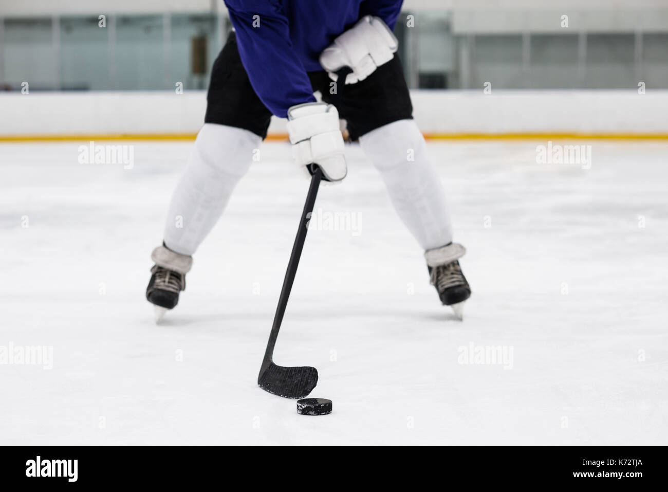La section basse de l'homme joueur de jouer au hockey à la patinoire de glace Banque D'Images
