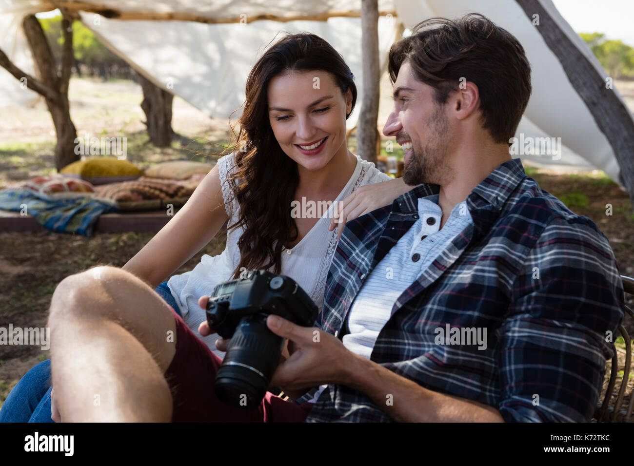 Smiling young man par femme avec caméra sur terrain Banque D'Images